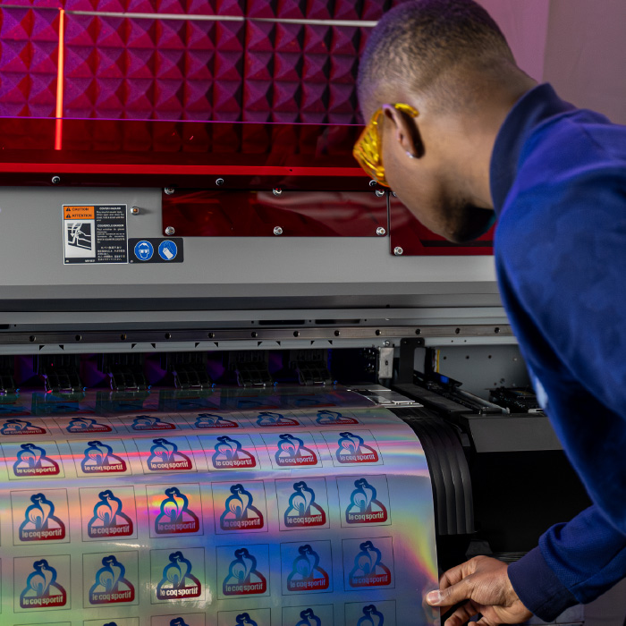 Impression de stickers holographiques Le Coq Sportif dans l’atelier Persecom à Lyon.