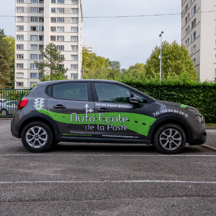 Voiture de l’Auto-École de La Poste floquée avec un marquage vert et noir, réalisée par Persecom à Lyon.