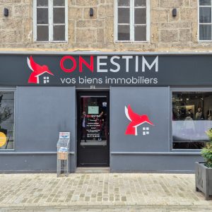 Façade de l’agence immobilière Onestim avec la nouvelle enseigne installée.