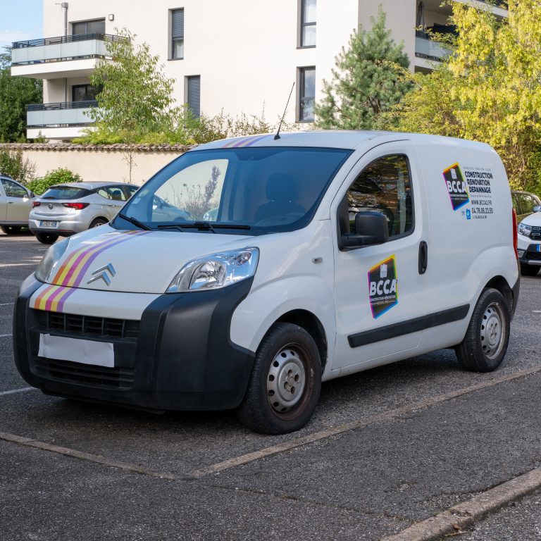 Petit utilitaire BCCA floqué avec bandes colorées et marquage latéral.
