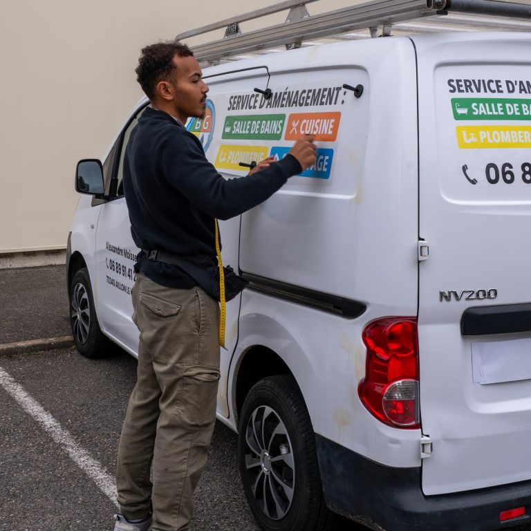 Technicien Persecom posant l’adhésif latéral sur l’utilitaire BGC à Lyon.