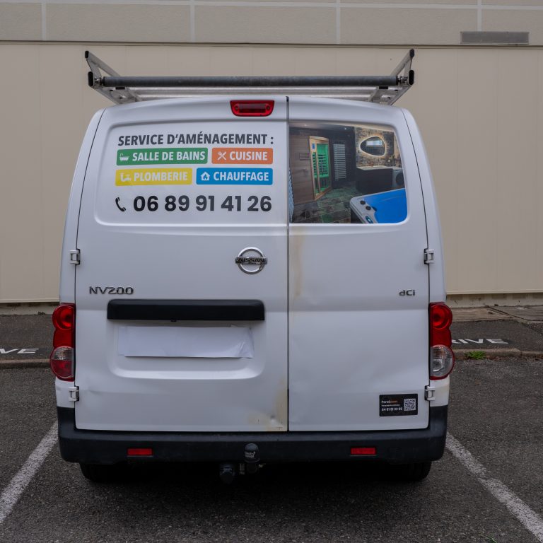 Vue arrière de l’utilitaire BGC avec marquage publicitaire et coordonnées visibles.