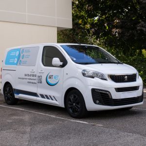 Utilitaire ArtNet floqué avec marquage latéral et avant, aux couleurs de la charte graphique.