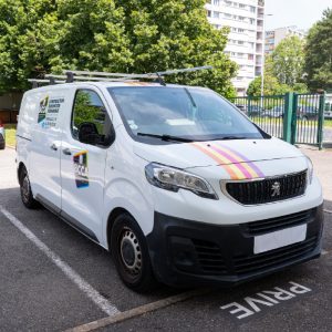 Utilitaire blanc BCCA floqué avec bandes colorées et marquage sur les portières.