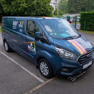 Fourgon bleu BCCA floqué avec bandes colorées et marquage professionnel installé à Caluire-et-Cuire.