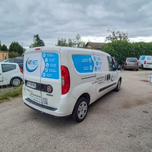 Utilitaire ArtNet floqué avec adhésifs bleus laminés, stationné après installation du marquage.