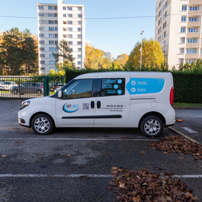 Véhicule léger ArtNet floqué avec marquage latéral, pictogrammes et bande bleue.