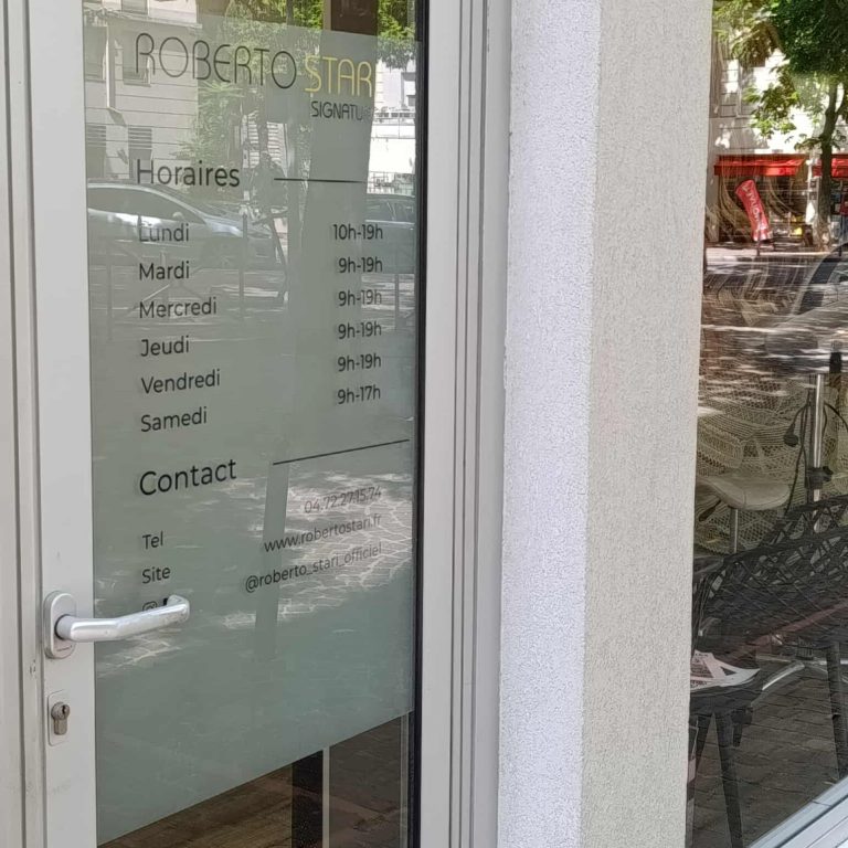 Vitrophanie dépoli avec horaires et contact sur la porte d’entrée d’un salon Roberto Stari.
