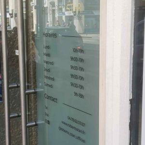 Détail du lettrage en vitrophanie sur la porte vitrée d’un salon Roberto Stari à Lyon.