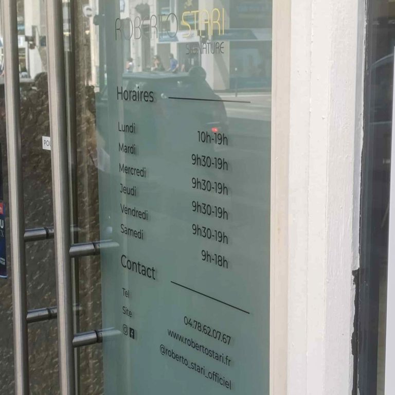 Détail du lettrage en vitrophanie sur la porte vitrée d’un salon Roberto Stari à Lyon.