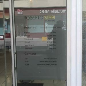 Vitrophanie avec horaires et coordonnées du salon Roberto Stari sur vitre en film dépoli.