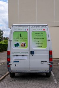 Dos du véhicule flocqué Harmony Thaï Massage avec visuels, textes et contact.