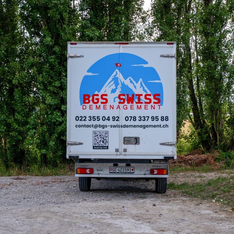 Face arrière du camion BGS Swiss avec logo géant et informations de contact.