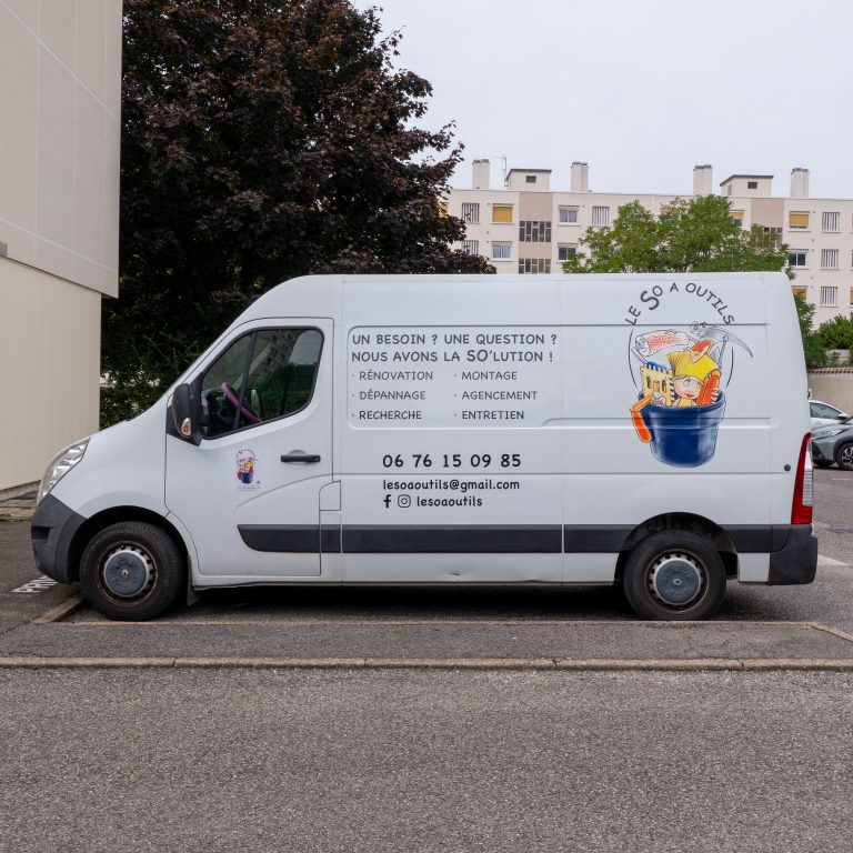 Vue latérale du véhicule utilitaire Le So à Outil floqué avec un marquage publicitaire à Lyon.