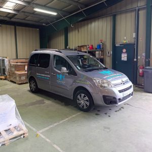 Véhicule léger de la flotte Direct Trans floqué et stationné dans l’entrepôt.