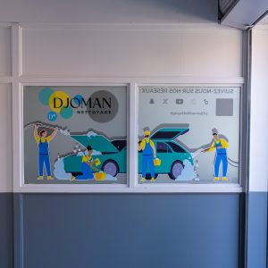 Décoration adhésive intérieure pour le garage Djoman Nettoyage à Vénissieux, avec illustration de lavage automobile sur les vitres.