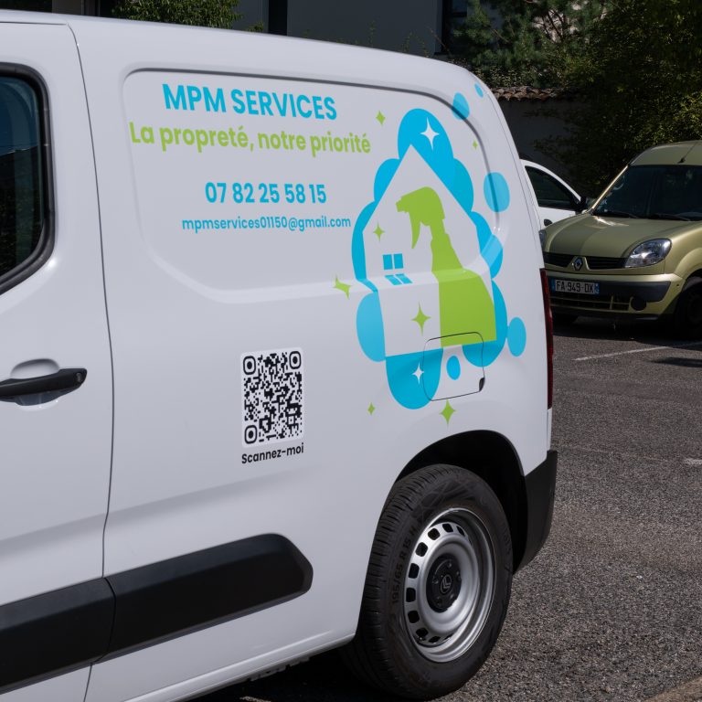 Détail du flocage latéral sur utilitaire MPM Services avec slogan et informations de contact.