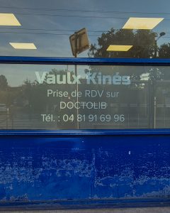 Film dépoli extérieur avec lettrage blanc installé sur la vitrine du cabinet Vaulx Kinés.