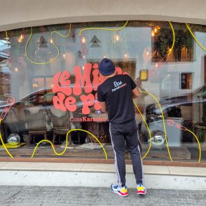 Pose vitrophanie intégrale à Megève : installation des adhésifs sur grande vitrine par Persecom Marquage