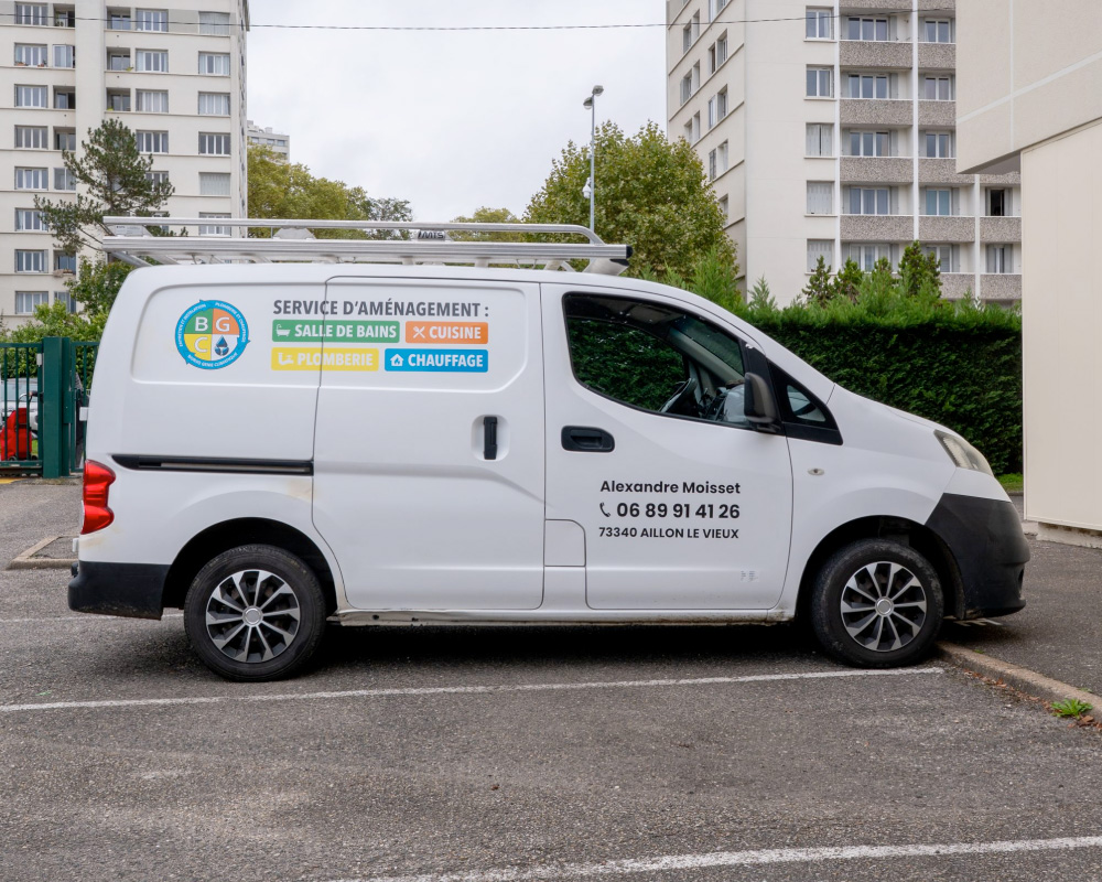 Utilitaire blanc avec marquage publicitaire appliqué sur les panneaux latéraux.
